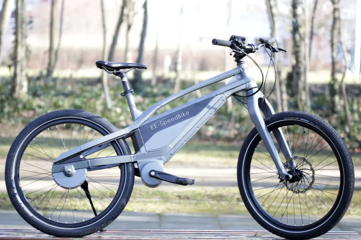 Moderne grijze elektrische fiets zonder ketting, met een strak design en een geïntegreerde accu.