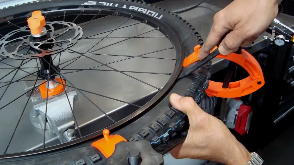 Fietsband monteren lukt niet. Een oranje bandenlichter helpt om de buitenband op de velg te krijgen.