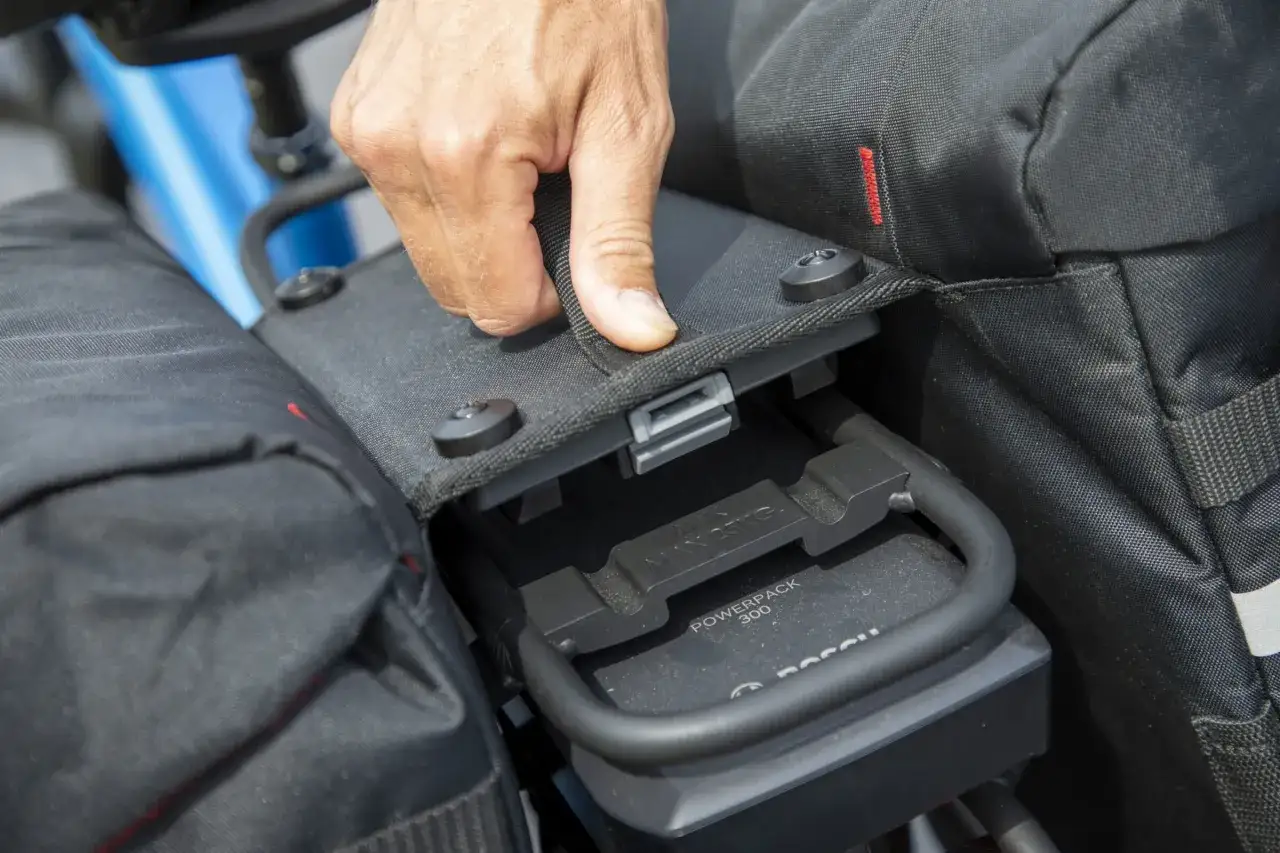 Hand opent tas om Bosch Powerpack te tonen, een kwetsbaar onderdeel voor mik-systeem diefstal.
