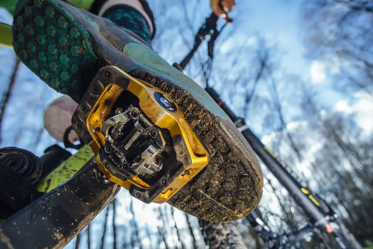 Een mountainbike schoen met modderige klikpedalen, klaar voor een off-road avontuur.