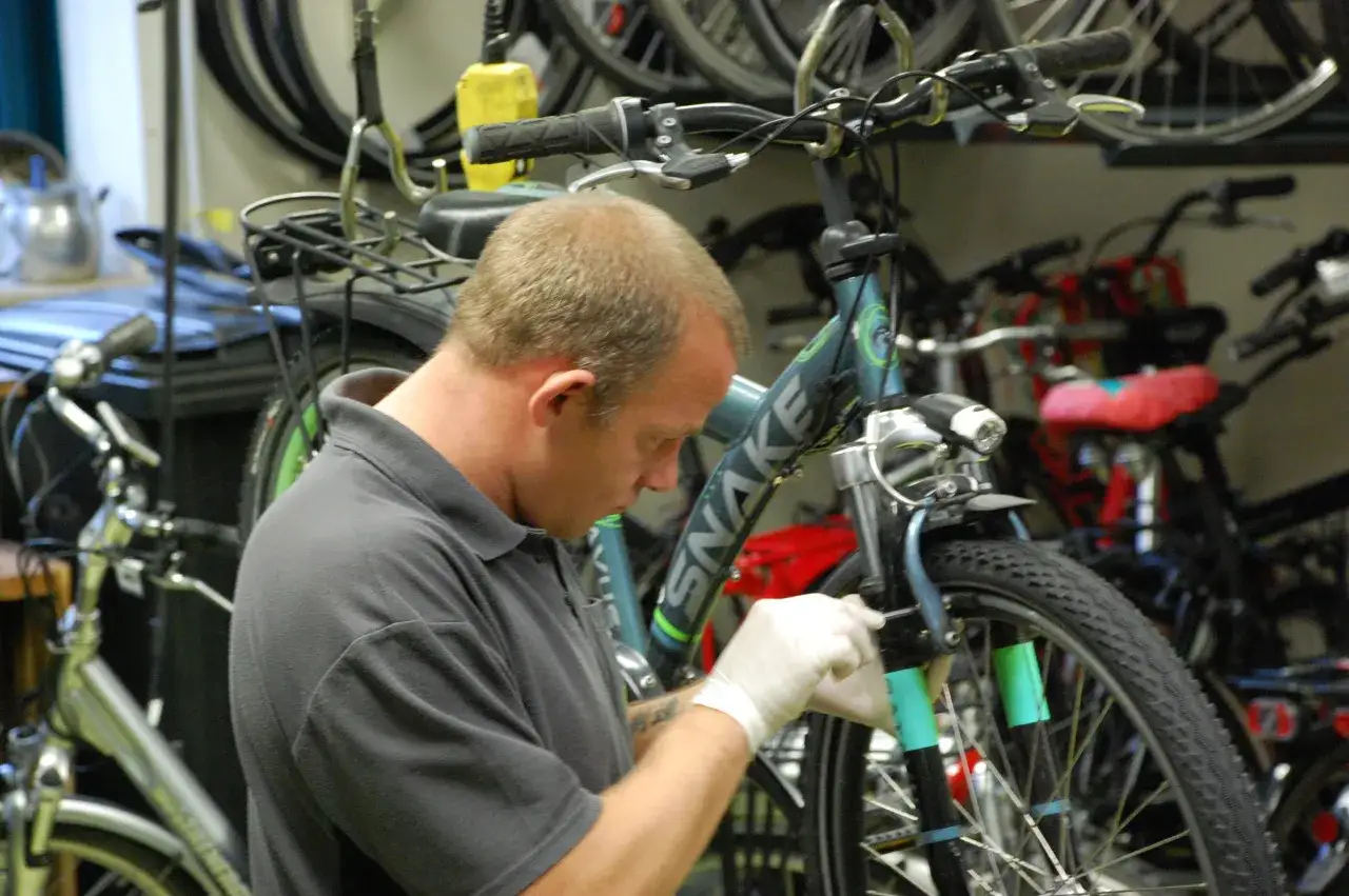Monteur vervangt schijfremmen fiets. Vraag naar de schijfremmen fiets vervangen kosten.