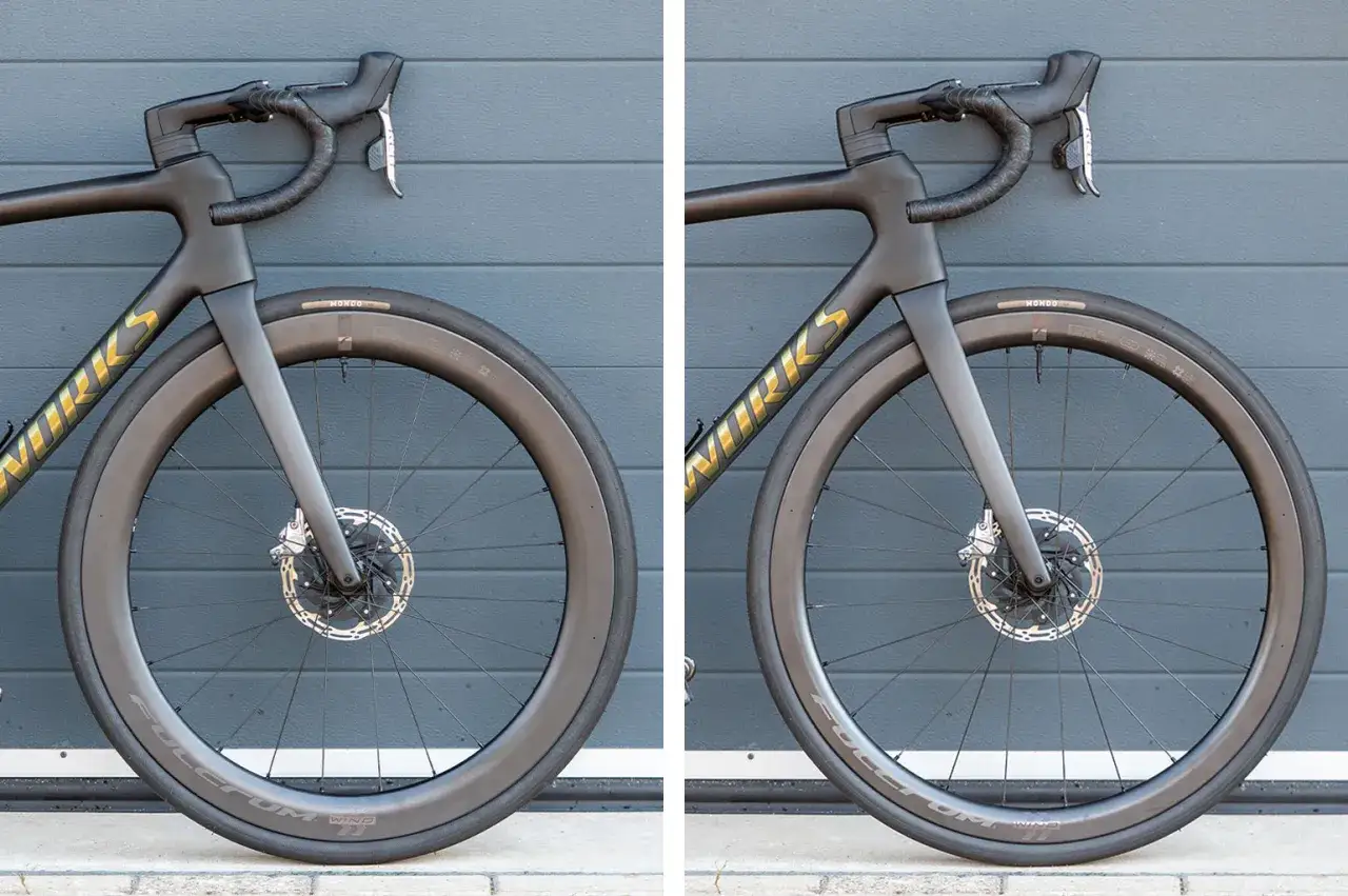 Zwarte racefiets met aerodynamische velgen. De velghoogte van deze racefiets is indrukwekkend.