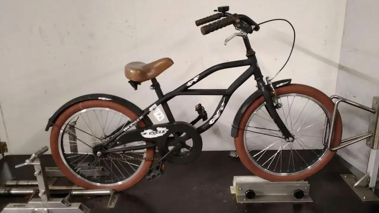 Zwarte beach cruiser met bruine banden en zadel. Klaar voor een ritje langs de kust.