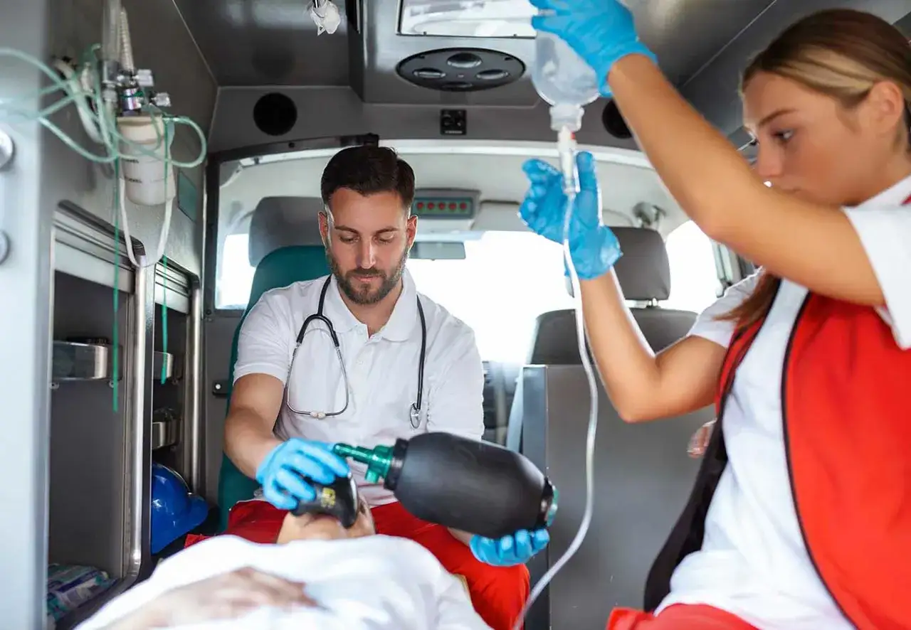 Ambulancepersoneel geeft spoedeisende hulp aan een pati&euml;nt na een fietser aangereden te zijn.
