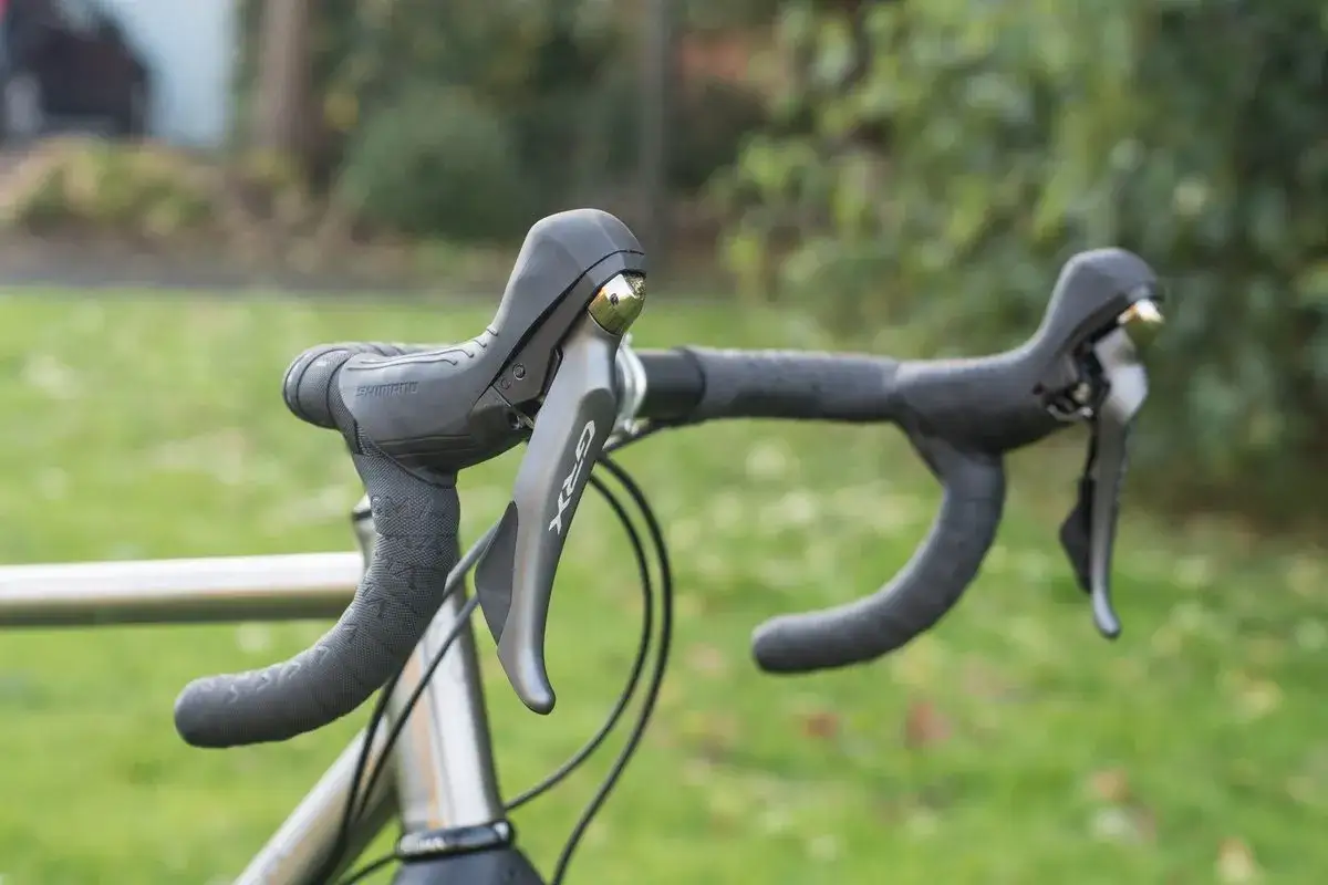 Shimano GRX schakelen racefiets. De stuuronderdelen zijn klaar voor elke rit, met een ergonomisch ontwerp voor comfort en controle.