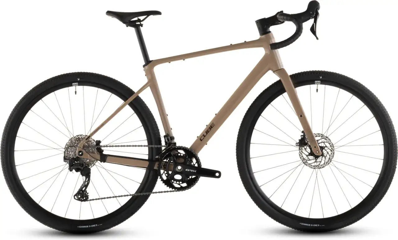 Een beige gravelbike, de Cube Nuroad Race, klaar voor avontuur. Deze fiets is perfect voor een review van ruig terrein.