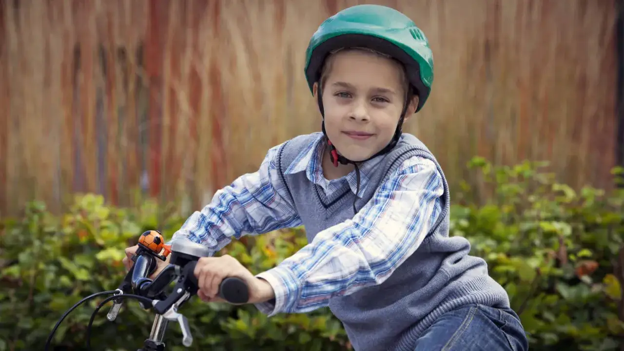 Jongen met groene fietshelm, klaar voor een ritje. Fietshelm verplicht in Frankrijk, dus veiligheid voorop!