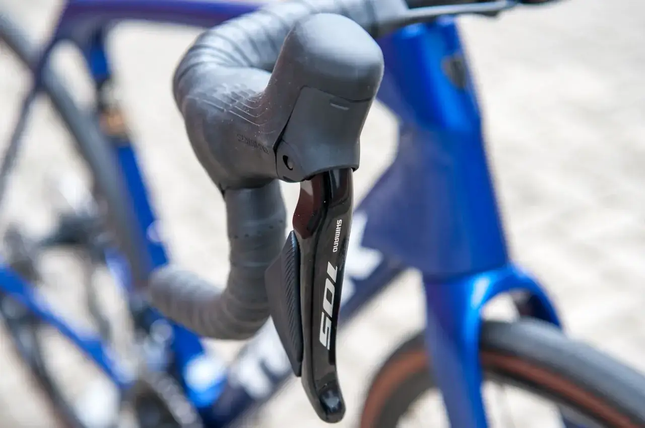 Shimano 105 derailleur op een blauwe racefiets. De keuze tussen Ultegra vs 105 is een veelvoorkomend dilemma voor fietsers.