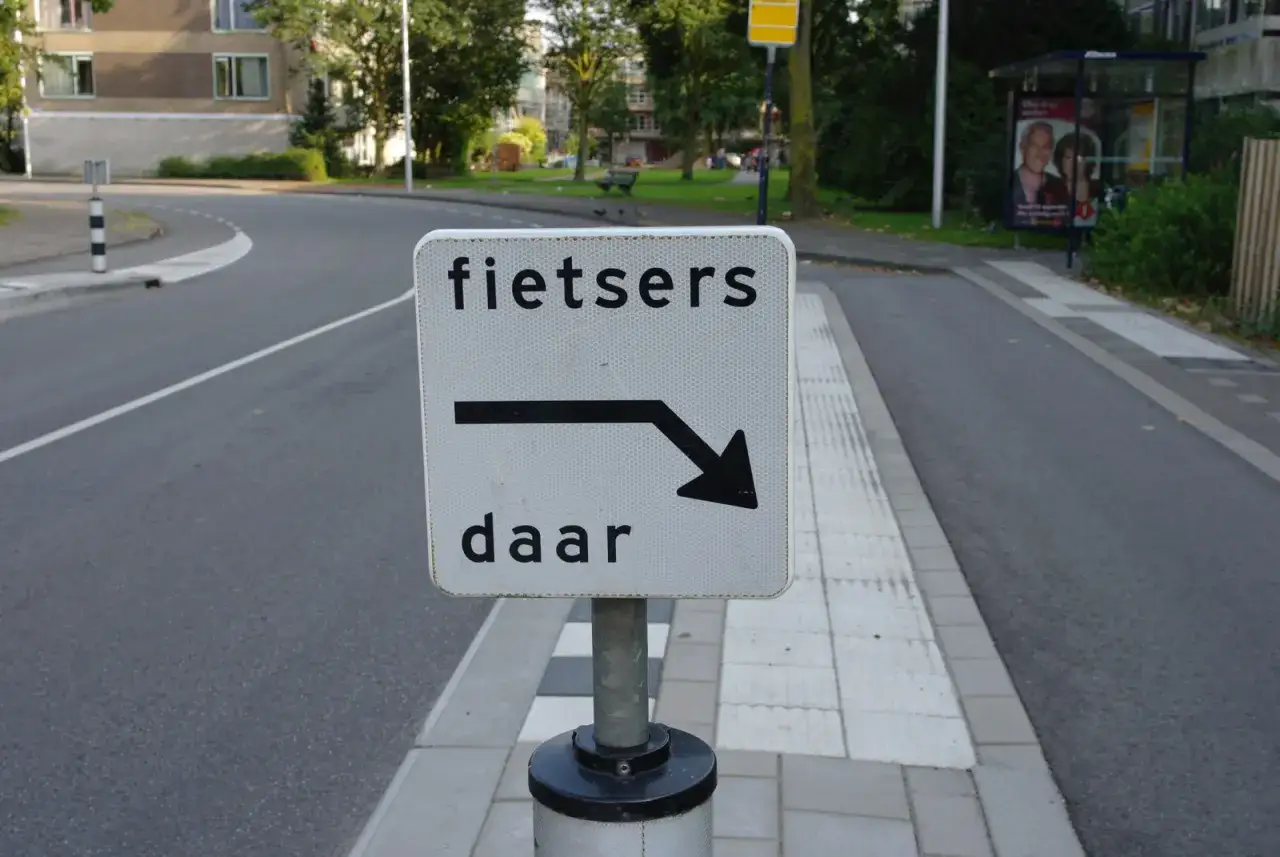 Verkeersbord 'Fietsers daar' met een pijl naar rechts. Dit betekent dat fietsers van rechts voorrang hebben.