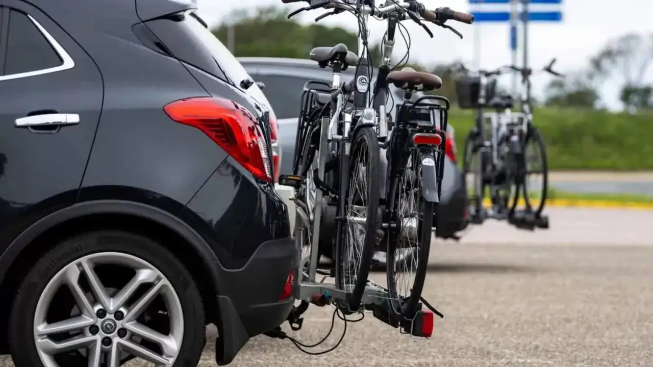 Twee fietsen op een fietsendrager achter een auto. De fietsen steken uit, wat vragen oproept over hoe ver mag een fiets uitsteken op de auto.
