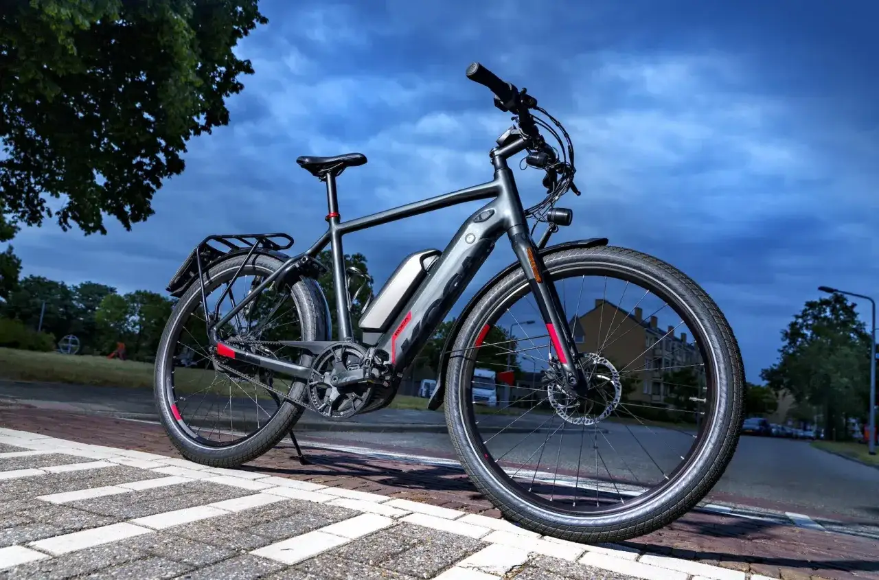 Een speed pedelec, een snelle elektrische fiets, staat op een betegeld fietspad. De accu is duidelijk zichtbaar.