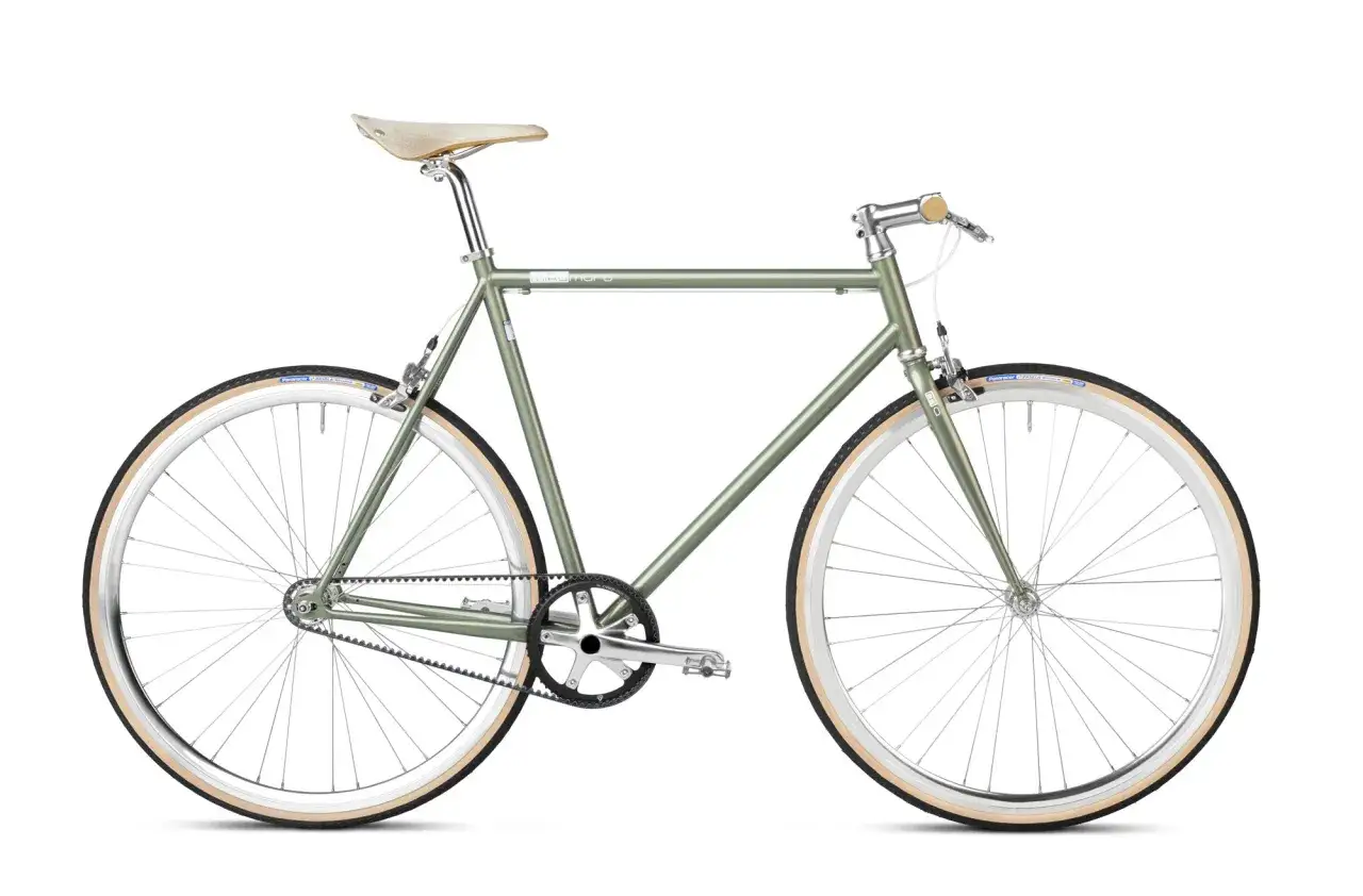 Groene fixie fiets met tandriemaandrijving en cr&egrave;mekleurige banden. Een fixie fiets is minimalistisch en direct verbonden met de wielen.