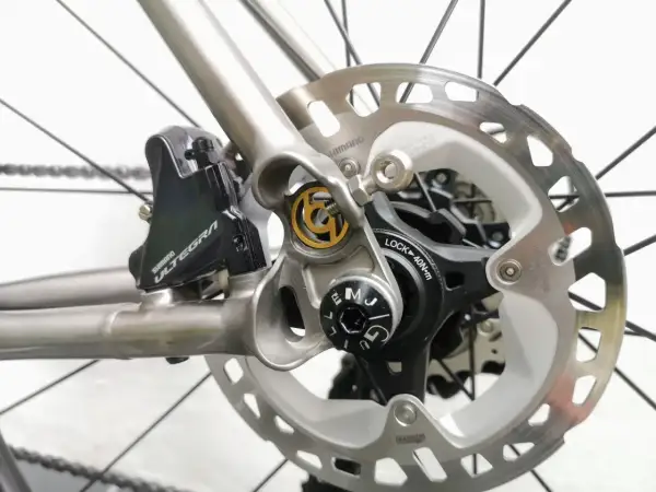 Close-up van schijfremmen op een racefiets. De Shimano Ultegra remklauw en schijfrem zijn duidelijk zichtbaar, klaar voor snelle afdalingen.