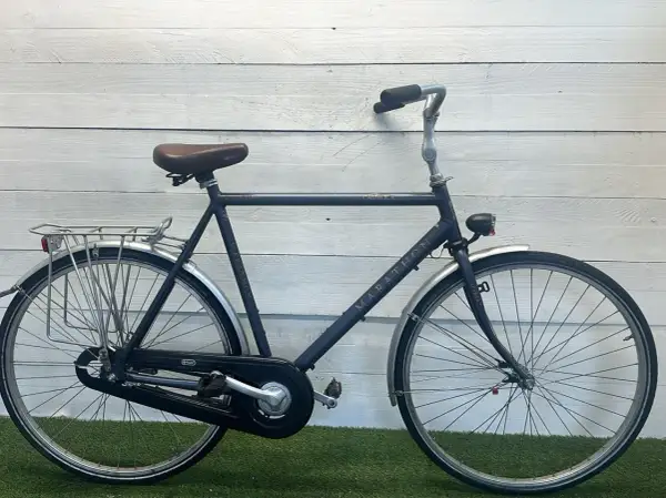 Een donkerblauwe Sparta Marathon, een klassiek model met een retro zadel en bagagedrager. Perfect voor lange ritten.