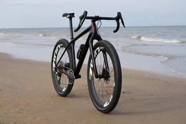 Zwarte racefiets met brede banden op het strand, klaar voor avontuurlijke beach bikes tochten langs de zee.