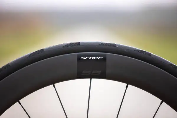 Zwarte velghoogte racefiets van Scope, met SS-logo.