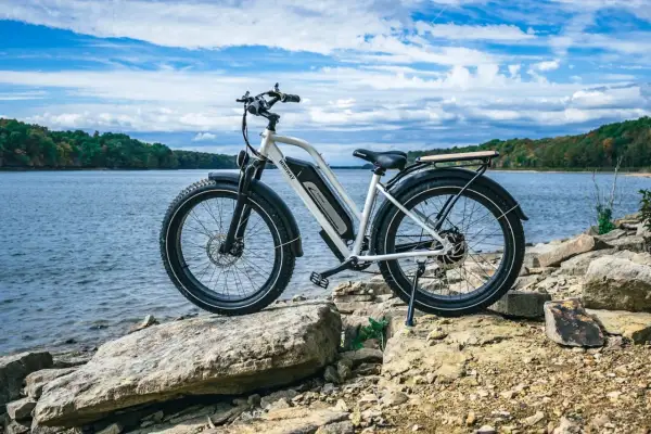 Een elektrische fiets staat op rotsen aan het water. De fiets is klaar voor een avontuur, hopelijk zonder ongelukken.