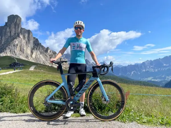 Man met racefiets in de bergen, genietend van gesoigneerd wielrennen.