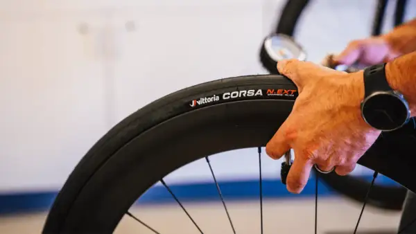 Hand controleert de bandenspanning van een Vittoria Corsa N.EXT tubeless racefiets band.